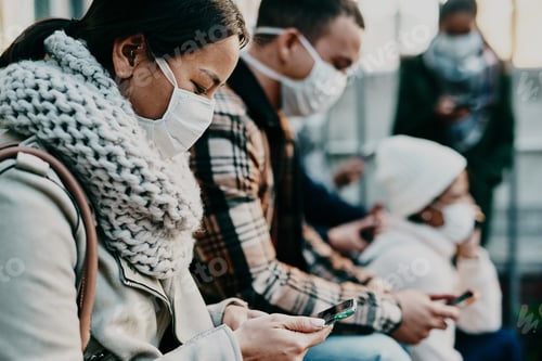 Preview: Shot of a young woman using a smartphone and wearing a mask while travelling in a foreign city