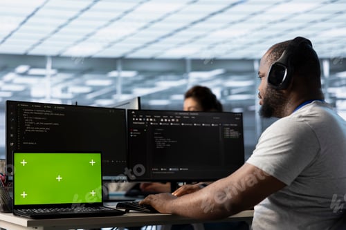 Preview: Mockup laptop in front of IT support workers coding, listening music