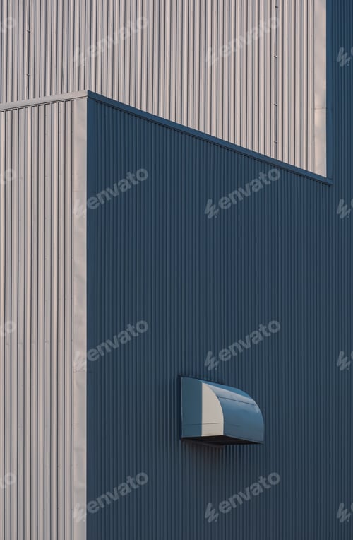 Preview: Sunlight and shadow on surface of air duct ventilation on gray corrugated metal industrial building