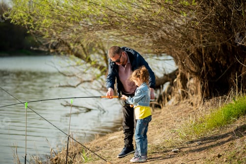 Preview: A dad and his daughter are fishing in the river.