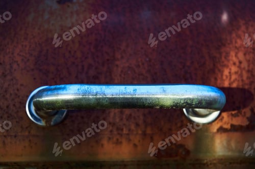 Preview: Closeup of a rusted BBQ grill handle outdoors