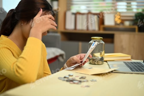 Preview: Stressed young woman calculating monthly expenses at home. Home budget and accounting concept