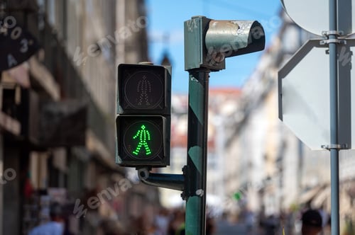 Preview: Green pedestrian signal guides foot traffic on a busy city street during daylight hours