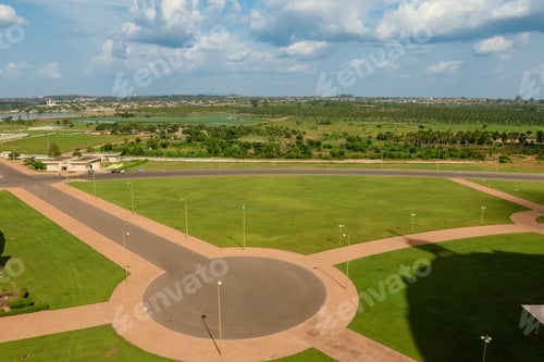Preview: Vast green landscape and paths in Ivory Coast under blue skies and clouds