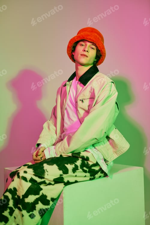 Preview: Fashionable young man exudes charisma in vibrant attire under modern studio lights