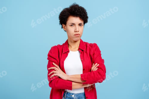 Preview: Portrait of sad unhappy woman wearing pink shirt looking at camera isolated on blue background
