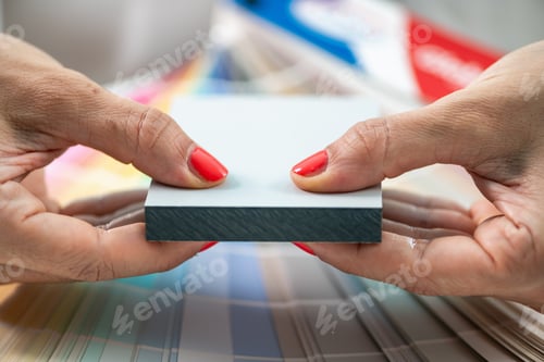 Preview: A designer holds up various compact board samples, demonstrating options for interior projects.