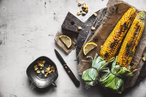 Preview: Grilled corn cobs with sauce, coriande on old shabby wooden white background. Mexican food. Top view