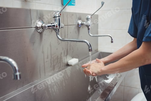 Preview: Female surgeon washing her hands