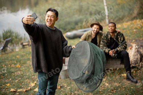 Preview: Asian man taking selfie on smartphone with friends