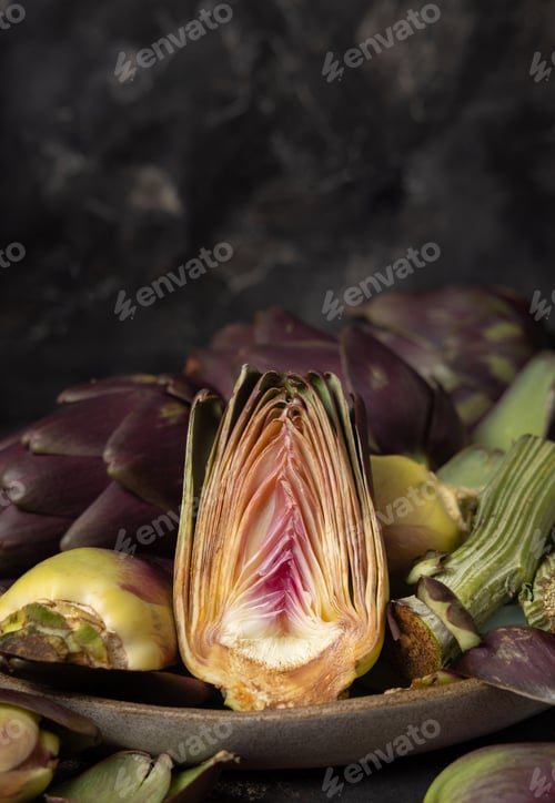 Preview: Plate full of cut purple raw artichokes closeup. Fresh italian vegetables from farmers market