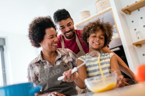 Preview: Happy black family in the kitchen having fun and cooking together. Healthy food at home.
