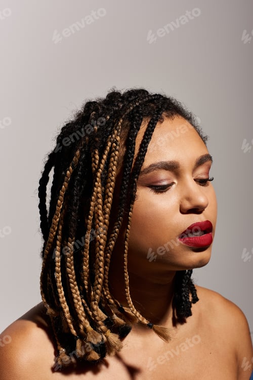 Preview: A young, stylish Black woman with braids and red lips poses in a modern studio