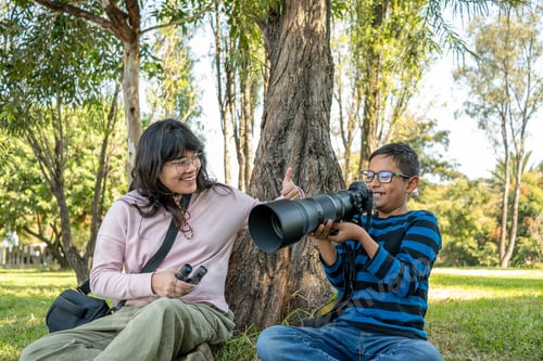 Preview: Mexican mother and son enjoying birdwatching hobby, using camera with telephoto lens