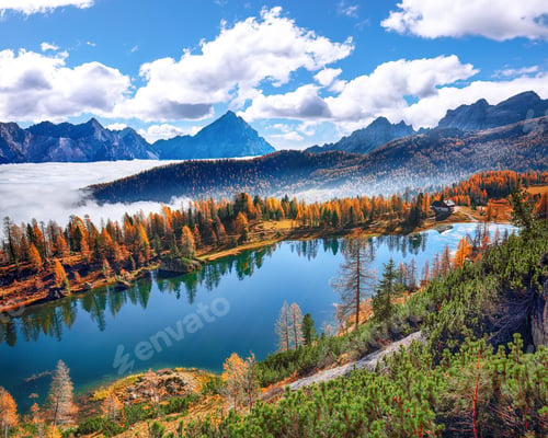 Preview: Stunning aerial view of crystal clear Lake Federa in Dolomites Alps under sunlight.