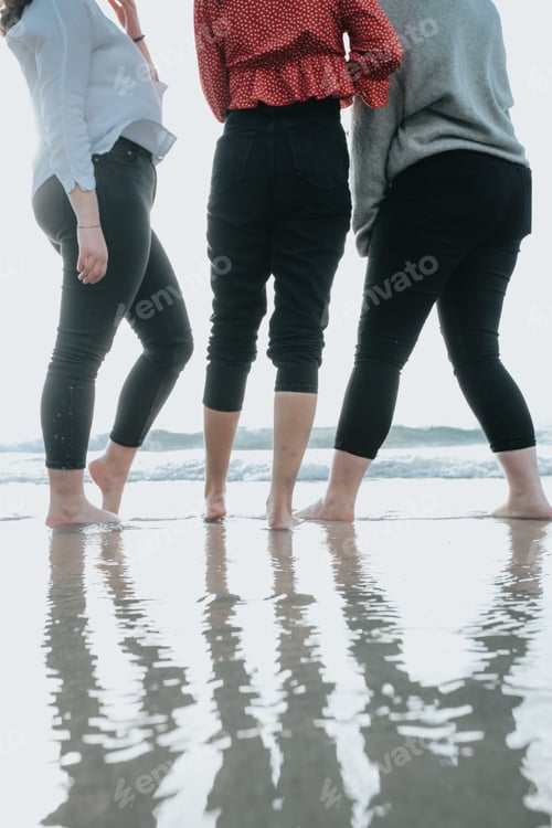 Preview: Close up of three women legs on the beach during a sunny day, vacation and relax concept