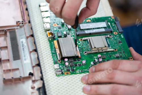 Preview: Service center for laptop repair. Macro of a screwdriver holding a screw.
