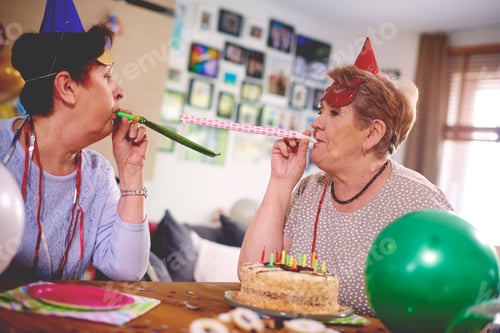 Preview: Senior women blowing party favor at each other