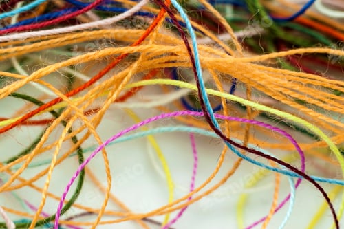 Preview: Multi-colored tangled colorful needlecraft silk thread rope. Macro shot. Abstract colors background