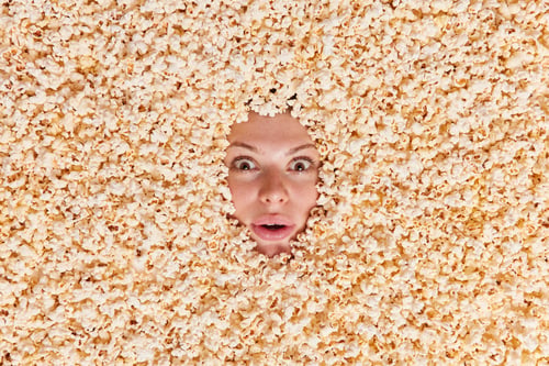 Preview: Overhead shot of surprised woman stares bugged eyes feels impressed being fully covered with delicio