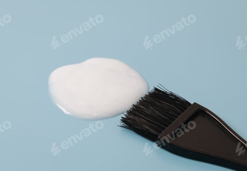 Preview: Hair dye brush and smear of white paint on blue.