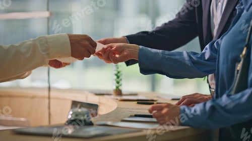 Preview: Closeup client hands paying contactless with mobile phone. Hotel guests check in