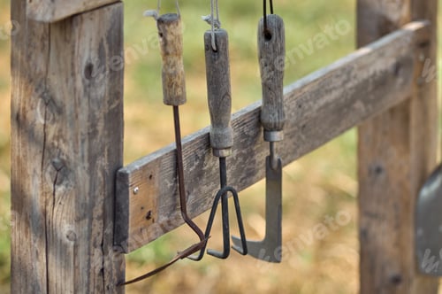 Preview: rusty gardening tools hanging on the wooden rack