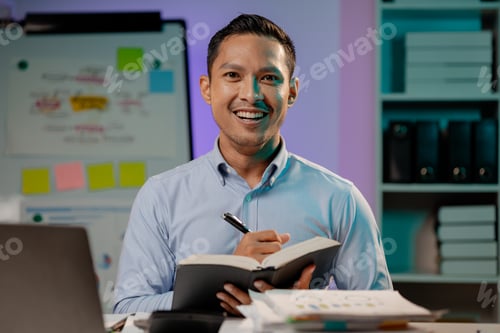 Preview: Asian man in dark office, company employee working overtime, working in the middle of the night, wor