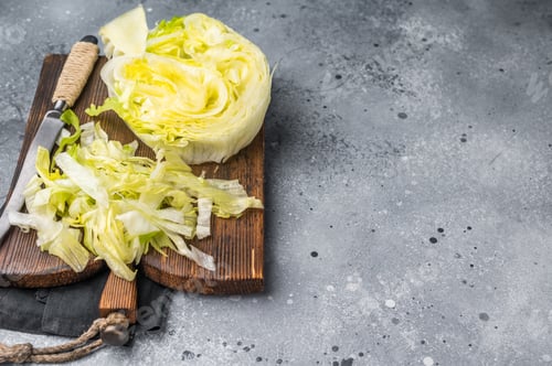 Preview: Fresh green iceberg lettuce salad sliced leaves. grey background. top view