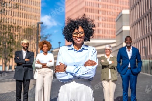 Preview: Happy entrepreneur standing proud next to her team outdoors