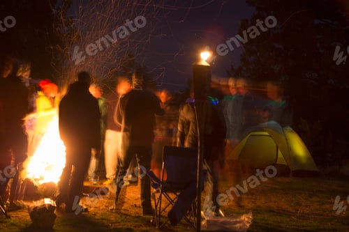 Preview: Friends gather around a warm campfire at night