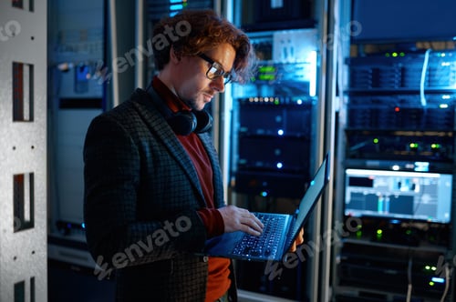 Preview: IT technician checking the servers vitals using laptop computer