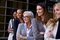Preview: Side view. Group smiling empowered diverse formal business women standing with arms crossed outdoor.