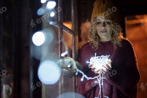 Preview: Female hold holidays lights on hands and looking. Amotion and feeling concept with woman