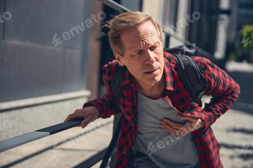 Preview: Middle-aged man suffering from heart attack outdoors