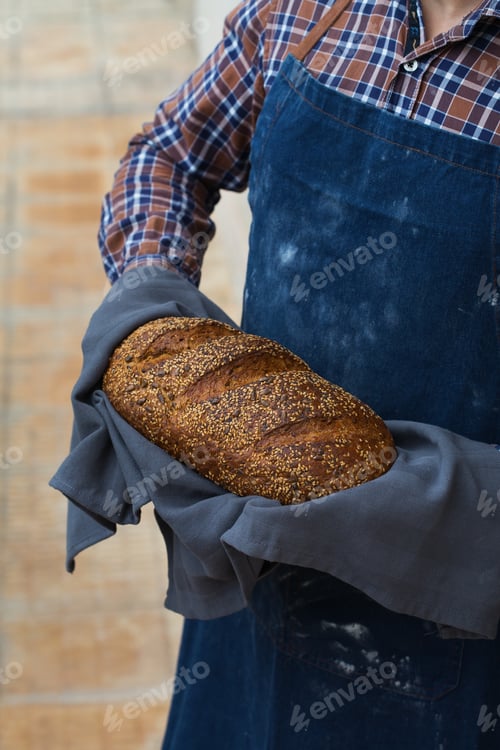 Preview: Fresh loaf of homemade rye bread in woman hands