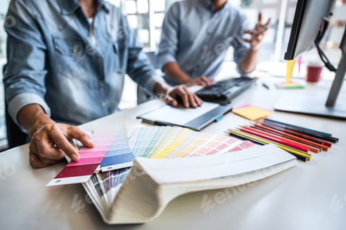 Preview: Young colleagues designers working together on a creative project and color samples for selection