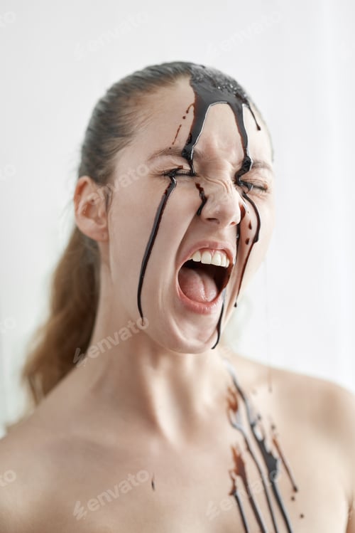 Preview: Emotion Concept. Woman standing isolated on white screaming emotional head in chocolate sauce