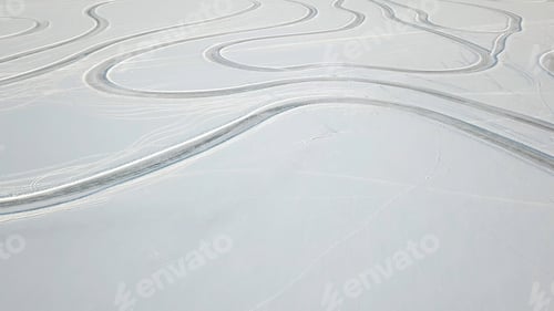 Preview: Aerial view on driving car at snowy track. One car driving through the winter forest on country road
