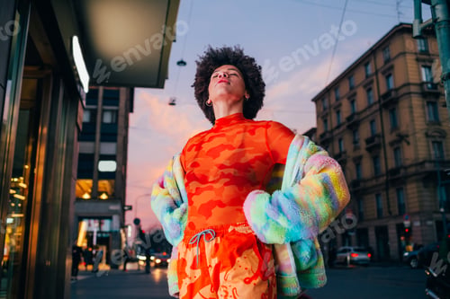 Preview: Proud young black woman posing outdoor city night strong and confident hands on hips