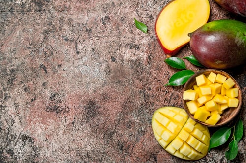 Preview: Mango pieces in a bowl with foliage.