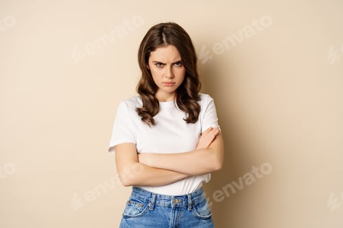 Preview: Offended angry woman cross hands on chest, frowning and sulking insulted, standing over beige