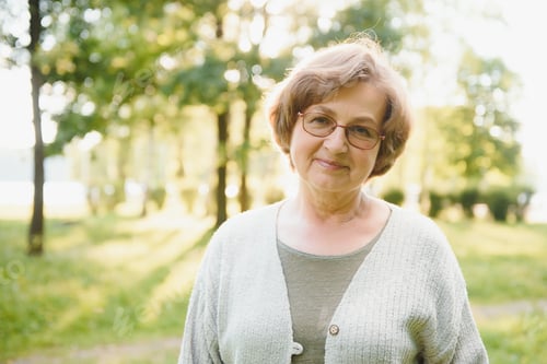 Preview: Smiling senior woman having recreation in park.