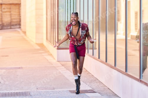 Preview: A gay man with braids talks on his cell phone. He smiles and makes a funny face