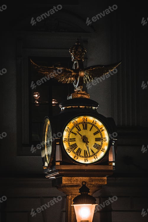 Preview: Vertical shot of street lamp and antique clock at night