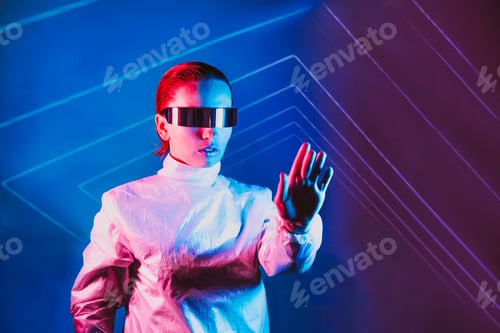 Preview: Neon portrait of woman, dressed in futuristic holographic clothes and glasses touch space by fingers