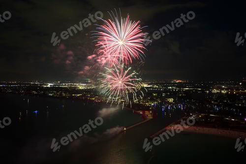 Visualização: Vista aérea de fogos de artifício brilhantes explodindo com luzes coloridas sobre a costa do mar