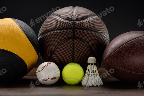 Preview: Closeup shot of various sports balls and shuttlecock on wooden surface