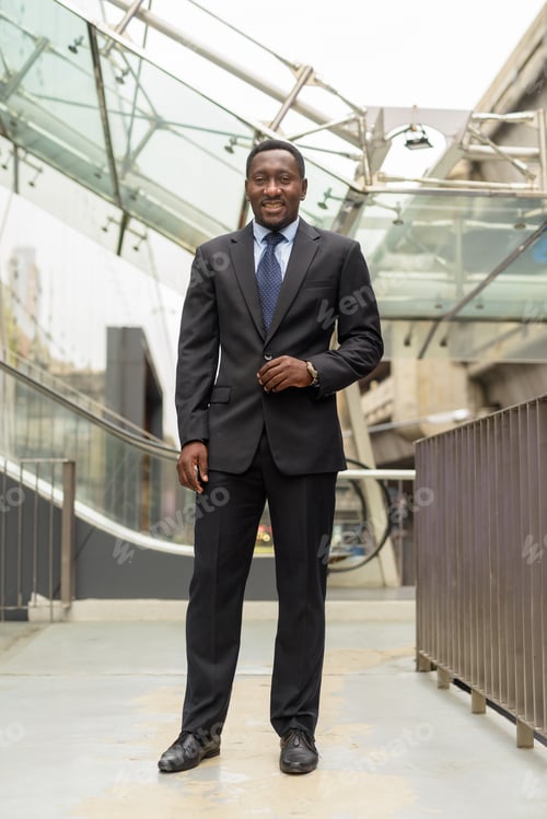 Preview: Full length portrait of handsome African businessman in city
