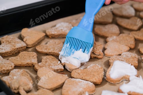 Preview: woman making heart shaped cookies in the kitchen, using silicon culinary brush
